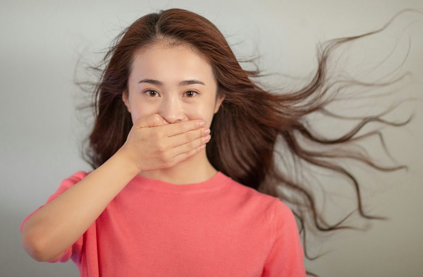 young woman covering her mouth