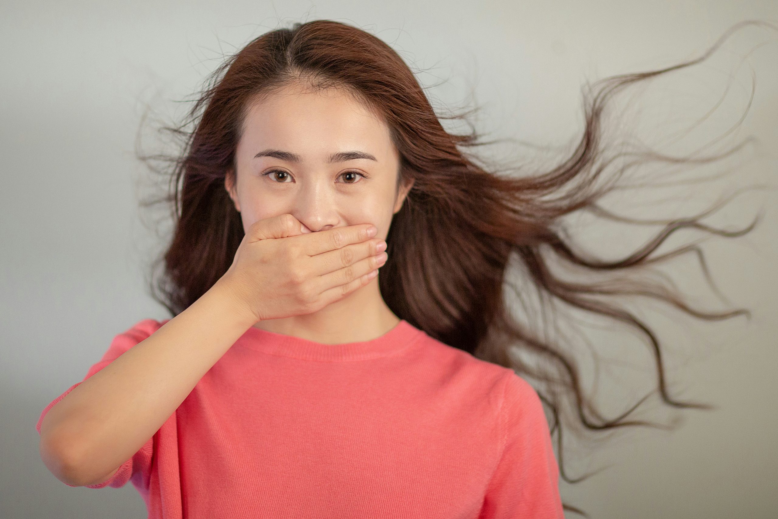 young woman covering her mouth