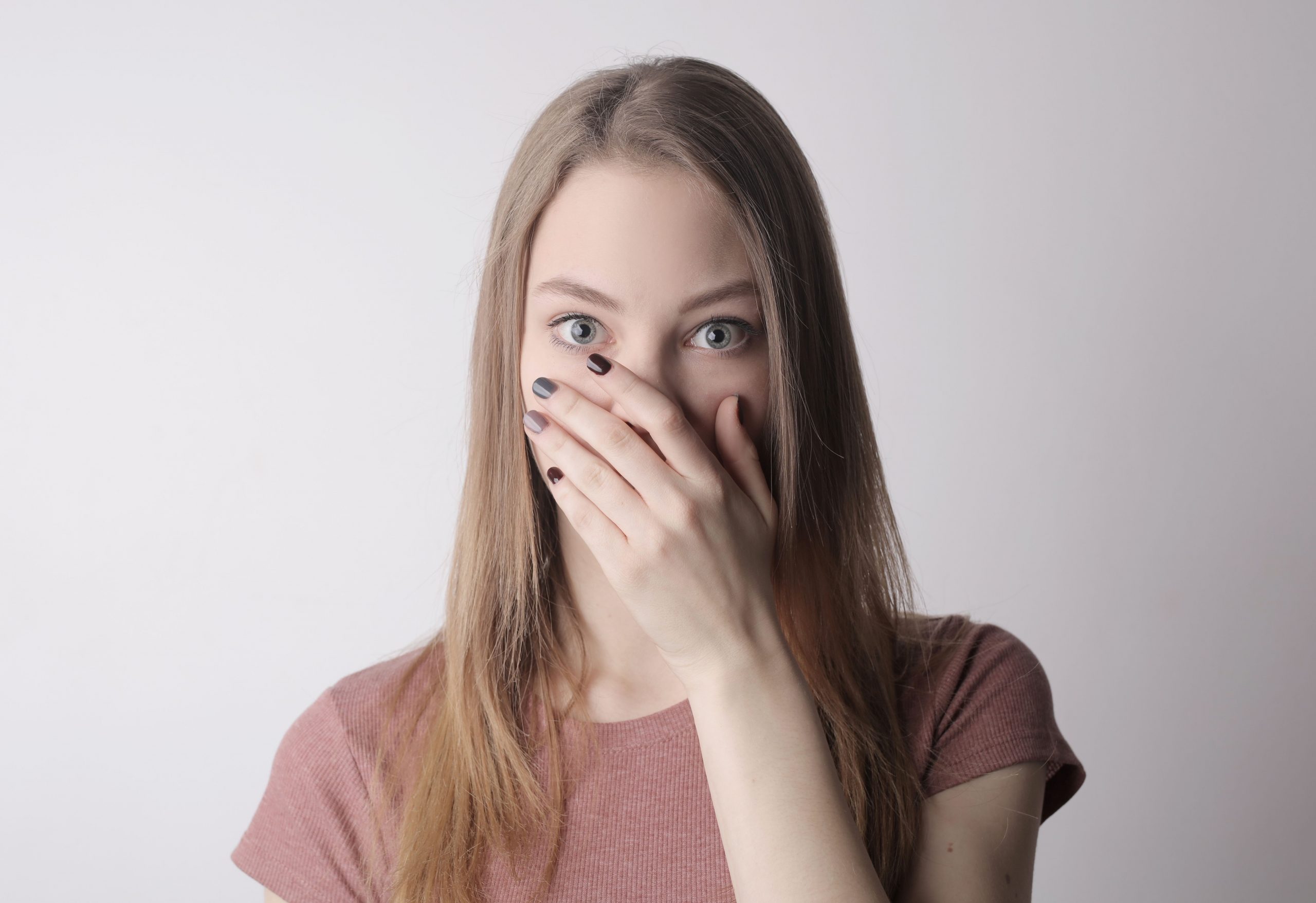 young woman covering her mouth